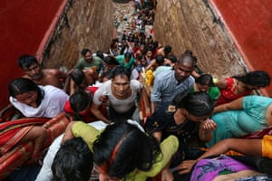 People who have taken a dip in a well climb a crowded set of steps