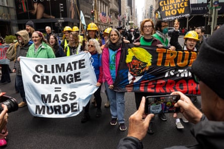 People hold signs protesting against Trump’s environmental policies