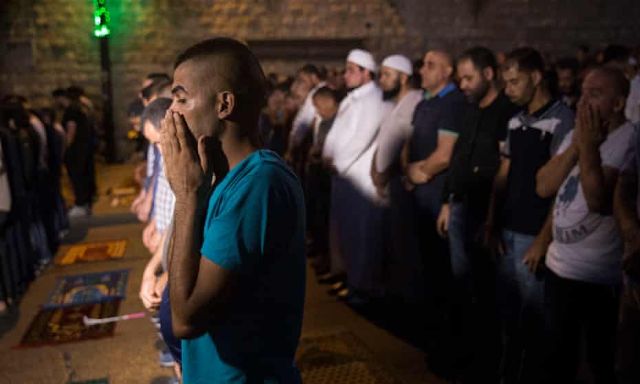 Palestinians pray in the street outside the flashpoint Lion’s Gate entrance to the Haram al-Sharif-Temple Mount compound that is home to the al-Aqsa mosque,the third holiest in Islam.