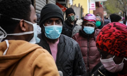 People wait for a distribution of masks and food in the Harlem neighborhood of New York City.