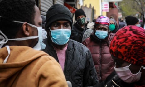 People wait for a distribution of masks and food in the Harlem neighborhood of New York City. 