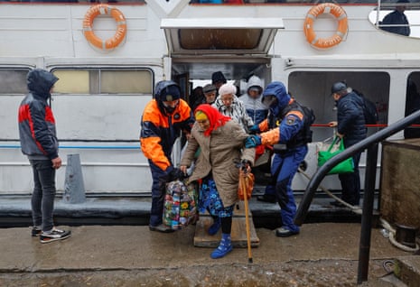 A woman steps off a ferry as civilians flee the Russian-controlled city of Kherson.