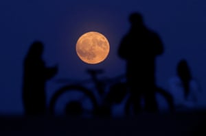 Las personas observan la luna de fresa desde Hampstead Heath, Londres, United Kingdom.