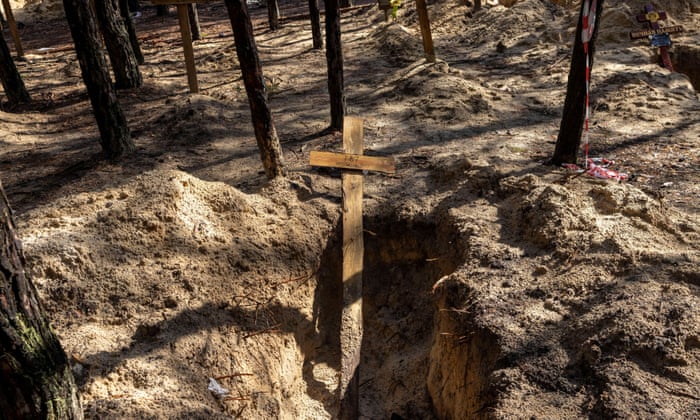 A cross is seen at a forest grave site during an exhumation, as Russia’s attack on Ukraine continues, in the town of Izium, recently liberated by Ukrainian Armed Forces, in Kharkiv region, Ukraine September 18, 2022. REUTERS/Umit Bektas