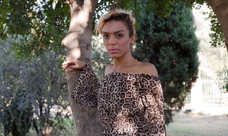 Yassmine, LGBT refugee, standing against a tree