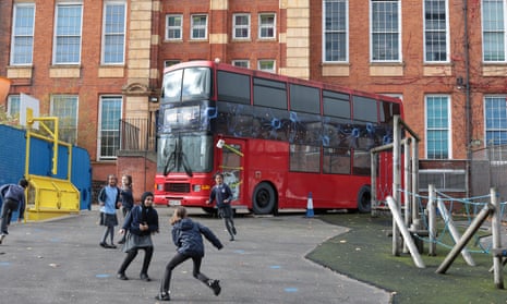 Children play by a double decker bus dressed up for Halloween