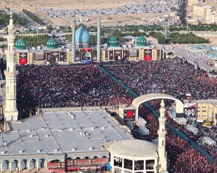 Huge crowd of people gather in front of a mosque