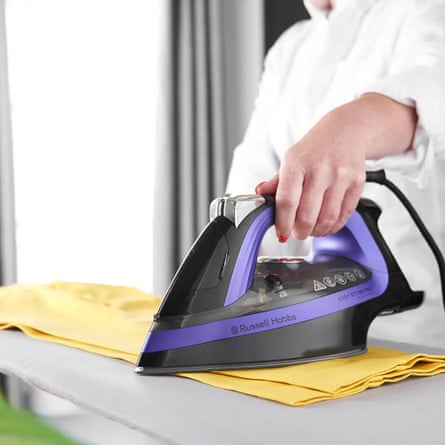Russell Hobbs Easy Store Pro Plug & Wind Iron is being used to press a piece of yellow fabric by a person wearing a white shirt.