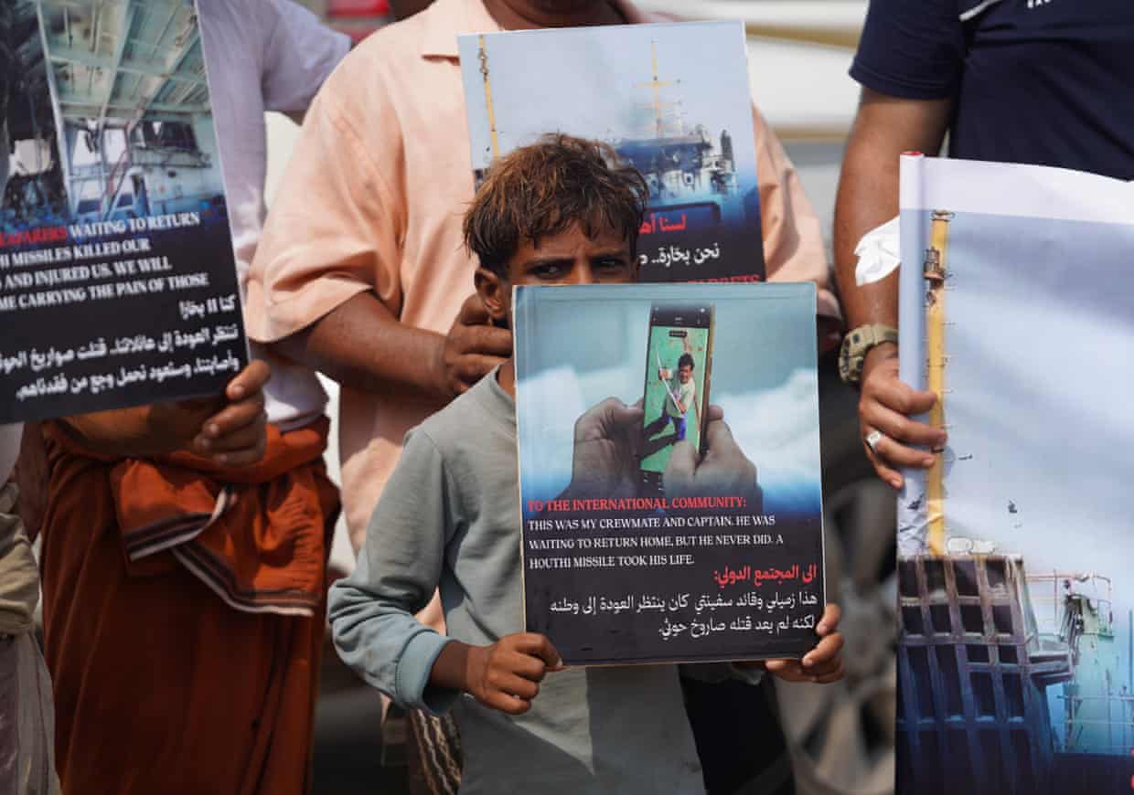 A Yemeni child holds up a placard among other people protesting against Houthi attacks in the Red Sea