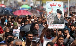 A picture of Moqtada al-Sadr is held up at a protest against corruption in Sadr City, Baghdad.
