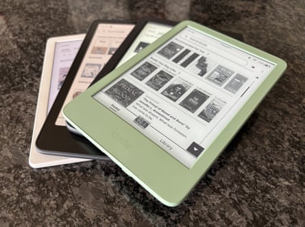 four e-readers piled on a table