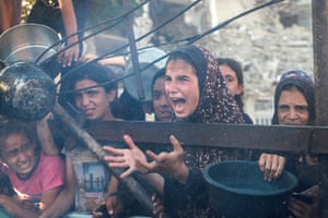 A Palestinian girl calls out for food from a charity kitchen