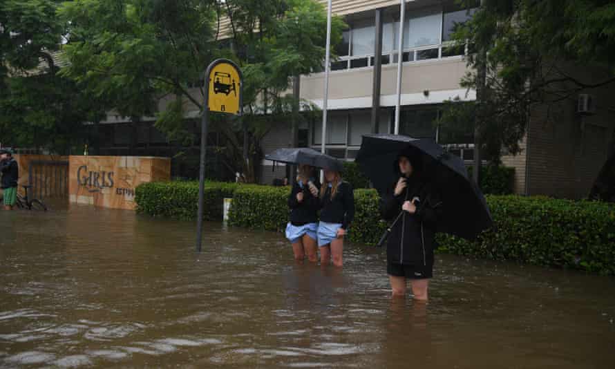 Mackellar Girls Campus students wait outside in knee-deep water on Tuesday