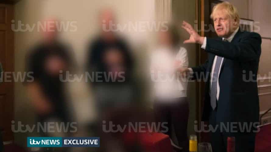 A photograph obtained by ITV News of the prime minister raising a glass at a leaving party on 13th November 2020, with bottles of alcohol and party food on the table in front of him.