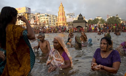 Indian devotees perform rituals as they take holy dips in the Godavari River during Kumbh Mela