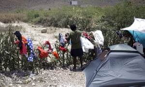 A woman picks up dry laundry at a camp for returned Haitians and Haitian-Dominicans, near the border with the Dominican Republic.