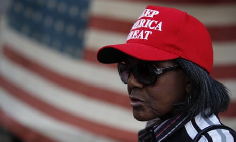A woman stands in front of an American flag, as a handful of supporters of President Donald Trump continue to protest outside the Pennsylvania Convention Center, in Philadelphia, Tuesday, Nov. 10, 2020. (AP Photo/Rebecca Blackwell)
