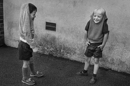 Two boys with their jumpers over their heads, Booker Avenue Primary School, Liverpool (1988), by Markéta Luskačová.