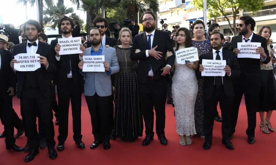 The cast and crew of Aquarius hold up signs of solidarity with the Brazilian president Dilma Rousseff at Cannes
