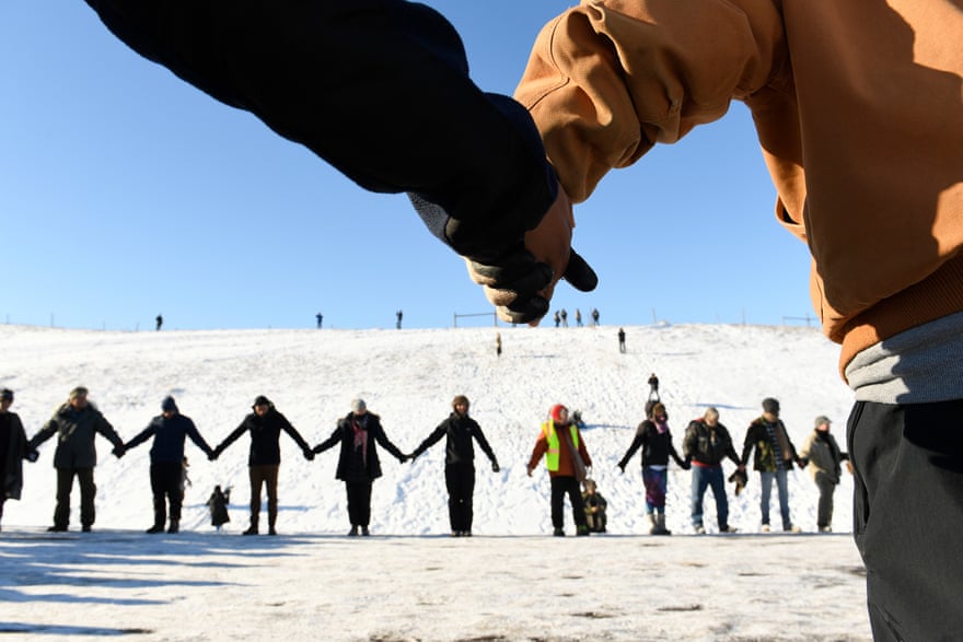 US veterans and Native Americans activists hold hands in prayer and solidarity at Standing Rock.