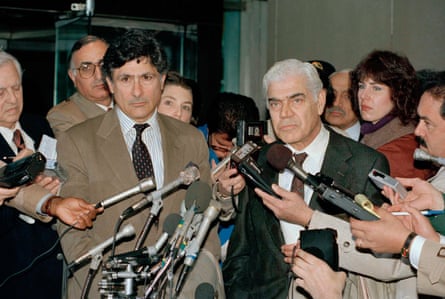 two men surrounded by reporters with mics
