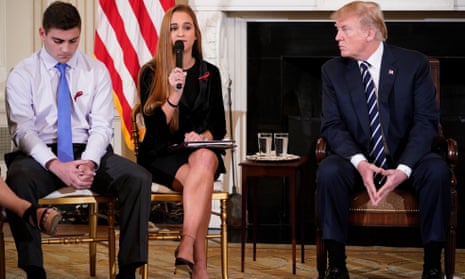 TOPSHOT - US President Donald Trump (R) watches as Julia Cordover (C), Parkland student body president, speaks during a listening session on gun violence in the State Dining Room of the White House on February 21, 2018. At right is Nicole Hockley of Sandy Hook Promise. / AFP PHOTO / MANDEL NGANMANDEL NGAN/AFP/Getty Images