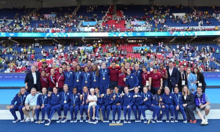 Players of the United States’s national team pose with coaching staff on the podium after the women’s gold medal match against Brazil at the Parc des Princes during the 2024 Paris Olympic Games