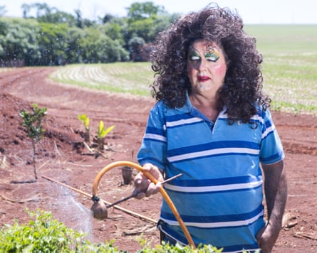 A man in drag watering plants