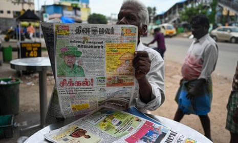 A man reads a newspaper reporting on the death of  Queen Elizabeth II at a tea shop in Chennai.