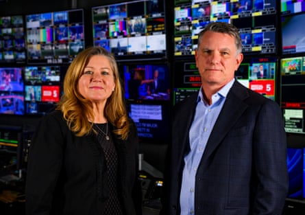 Oriana Zill de Granados (left) and Michael Rey pose in front of screens at the CBS studios