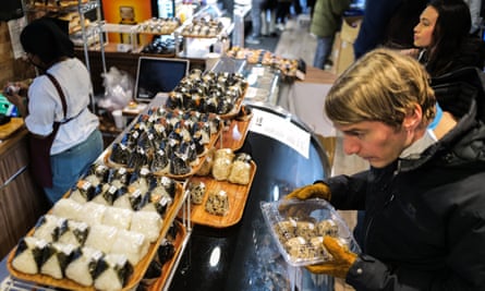 A customer chooses onigiri from a counter