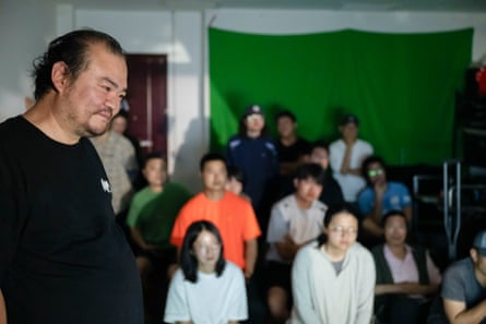 Man and young students in film class