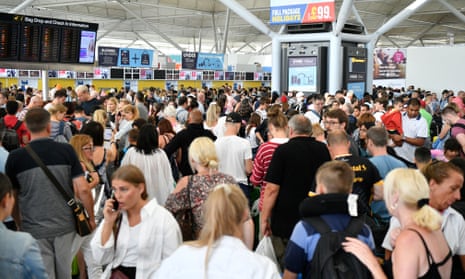 Passengers queue at London’s Stansted airport