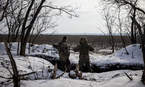Oleg (left) and another soldier from the 68th brigade look out towards Russian occupied land from their frontline position in southern Donbas.