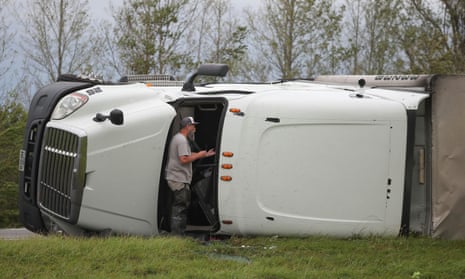A passer-by Chuck Balsamo communicates with a driver of an overturned 18 wheeler truck in aftermath of Hurricane Laura in Vinton, Louisiana.