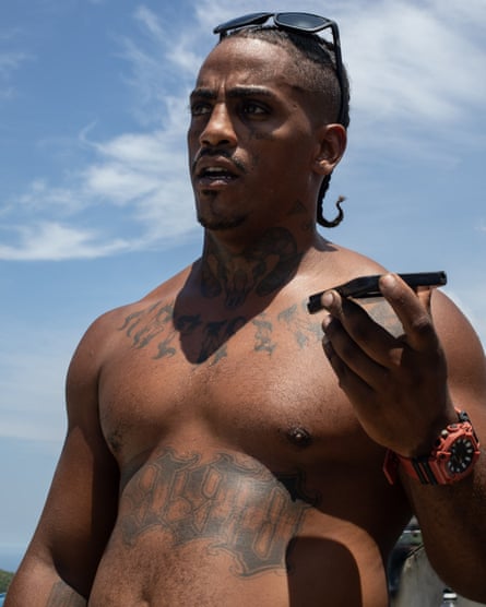 A shirtless Vitor Hugo Oliveira da Conceição talks on his mobile phone