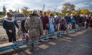 A Ukrainian army soldier at a crossing point inspects items being carried in to the rebel-held area.