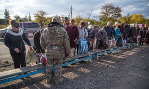 A Ukrainian army soldier at a crossing point inspects   items being carried in to the rebel-held area.