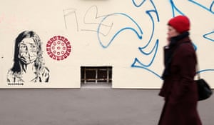 Berlino, Germania Graffiti di una donna che indossa una maschera protettiva accanto a un'immagine del coronavirus