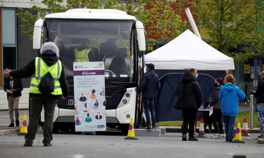 People line up outside a mobile vaccination centre, in Bolton