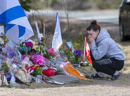 Woman mourns at roadside memorial for the 22 victims of the 2020 shootings
