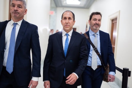 three men in suits walking in hallway