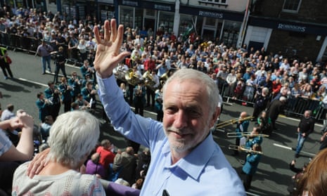 Jeremy Corbyn stands on the balcony of the County Hotel as colliery bands pass below.