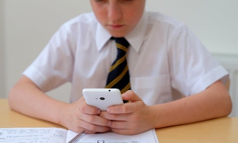 School pupil distracted by mobile phone.