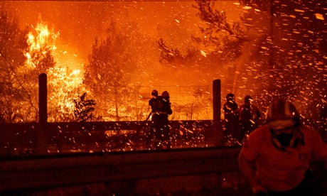 Οι πυροσβέστες προσπαθούν να σβήσουν τη φωτιά καθώς οι φλόγες εξαπλώθηκαν σε έναν αυτοκινητόδρομο κατά τη διάρκεια πυρκαγιάς στη βόρεια Αθήνα, Ελλάδα