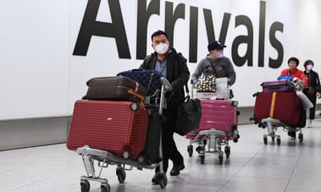 People wearing face masks arrive at Heathrow Airport