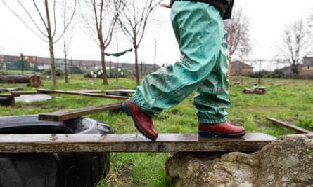 A child walking across a plank outside the nursery