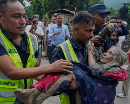 Rescuers carry an elderly woman to safety