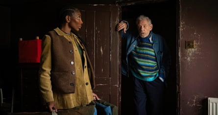 A woman standing looking at a man in a doorway