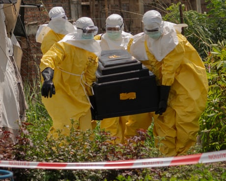 Red Cross workers carry the coffin of a person who died of Ebola